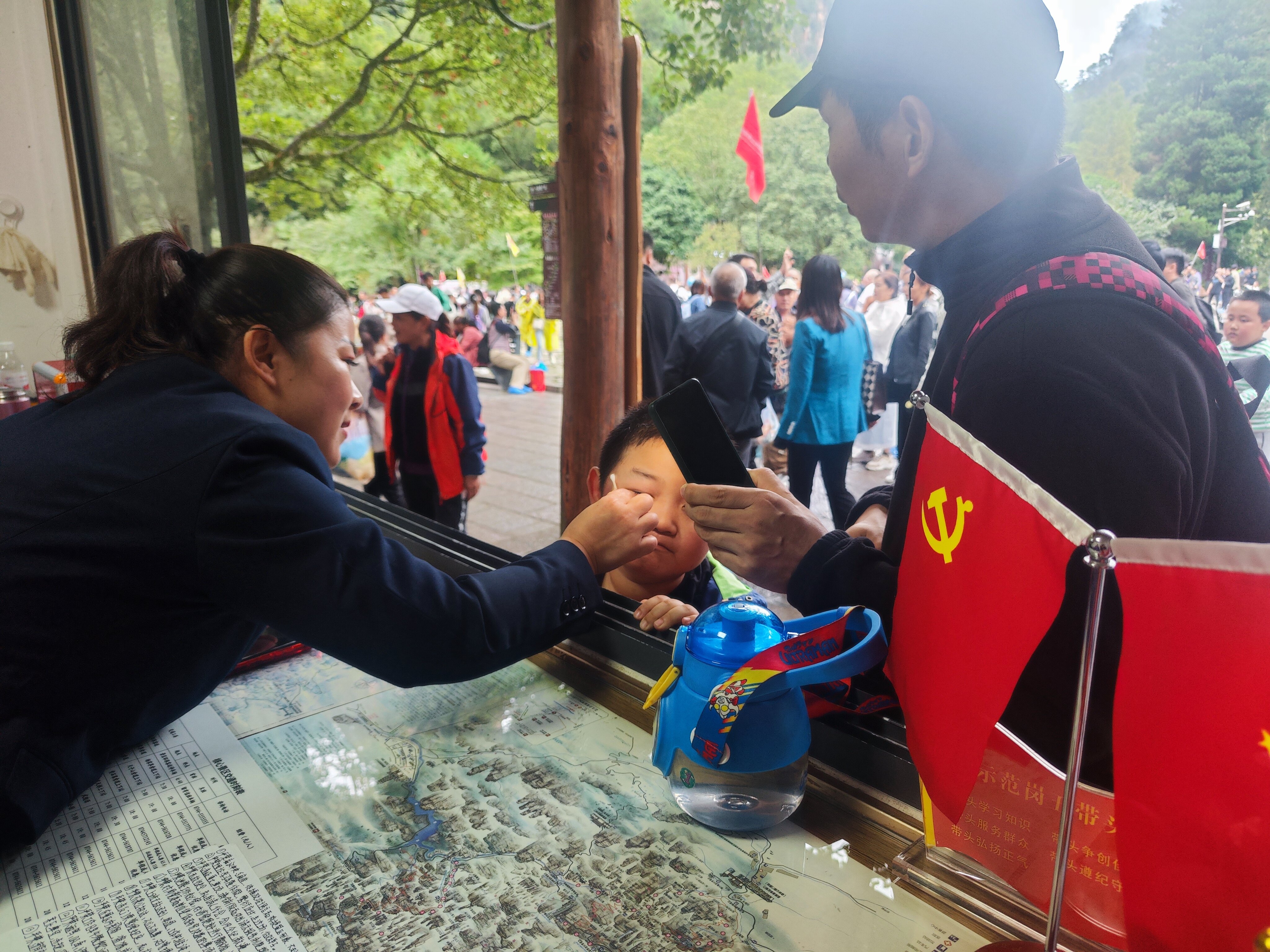 老磨灣黨員義務(wù)咨詢臺黨員為小游客處理被蜜蜂蟄傷傷口。張娜 攝