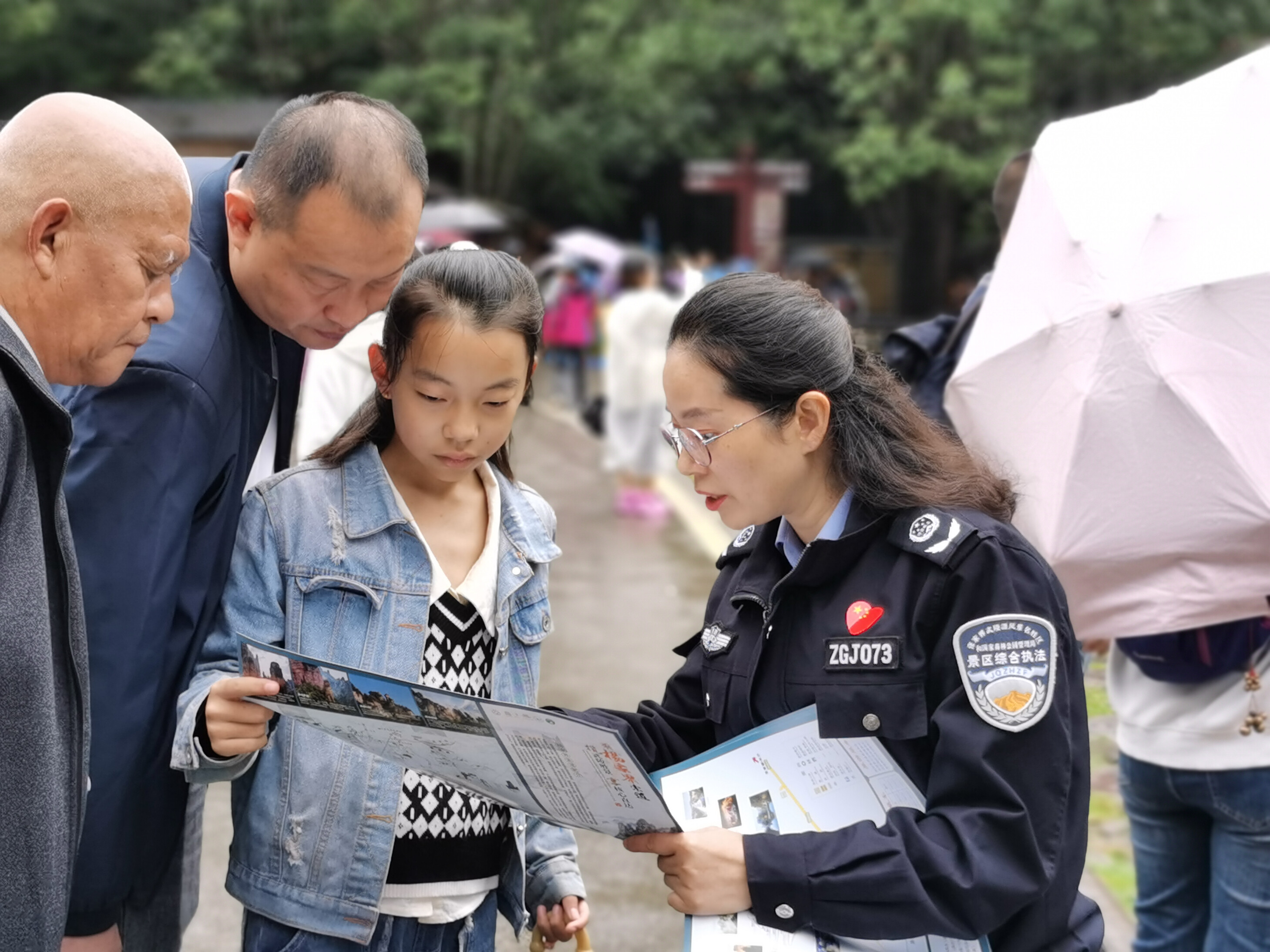 10月1日上年，金鞭溪景區(qū)管委會(huì)女子執(zhí)法隊(duì)隊(duì)員開展流動(dòng)導(dǎo)覽服務(wù)，為游客免費(fèi)贈(zèng)送地圖。張娜 攝